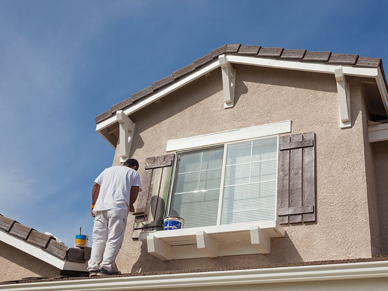 Man painting shutters