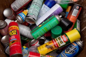 Bug spray cans gathered in order to be recycled. If there are still contents within the can, they will be properly processed by a household hazardous waste-processing facility.
